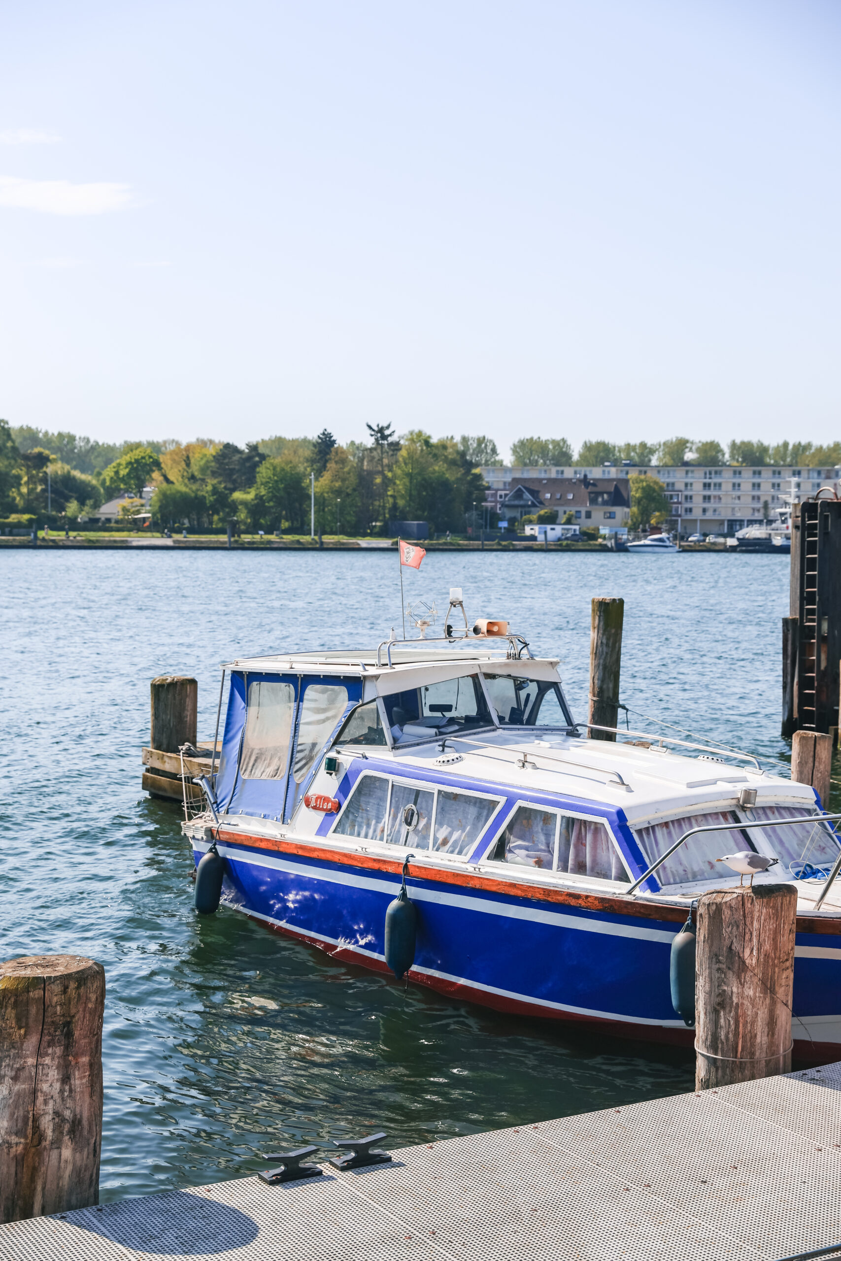 Ein blaues, kleines Boot an einem Anleger am Hafen von Travemünde