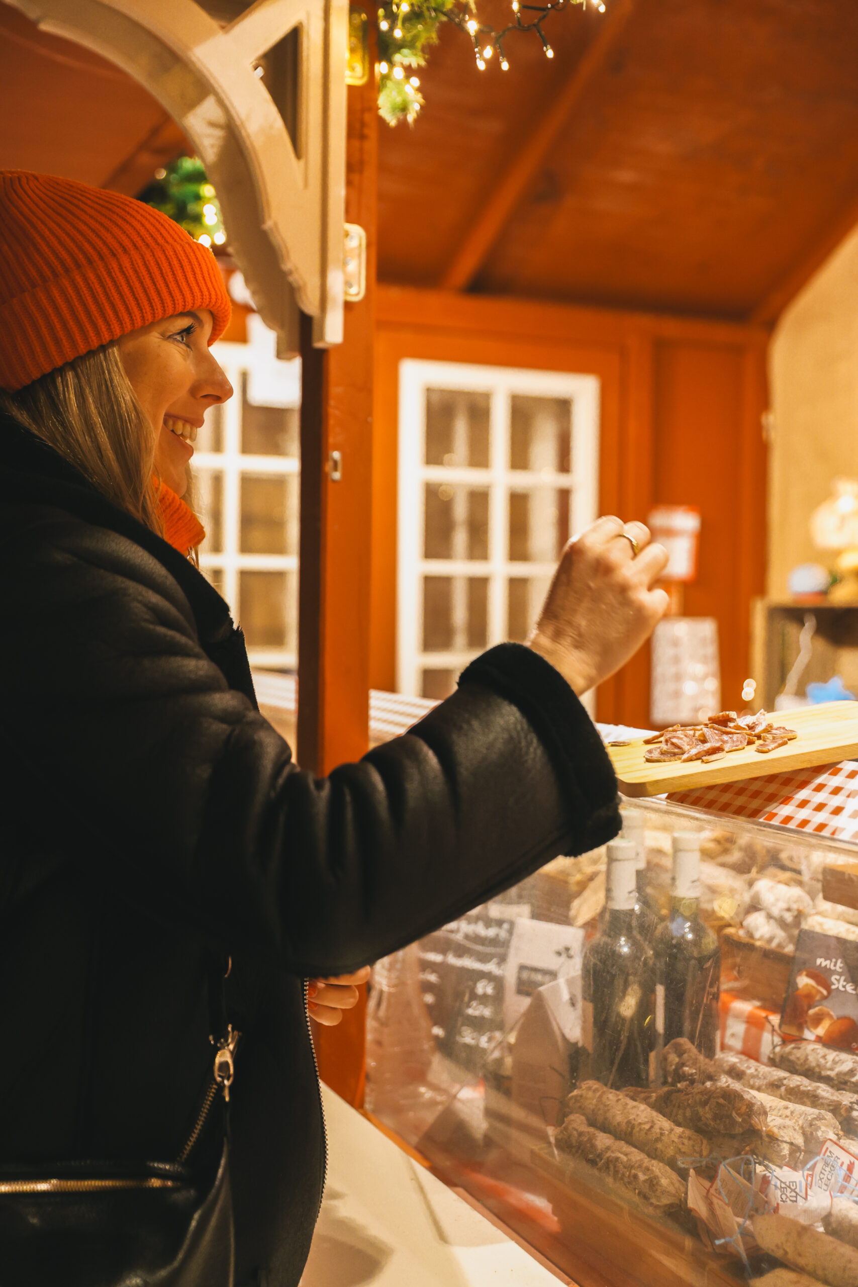 Kathrin probiert Salami auf dem Kieler Weihnachtsmarkt