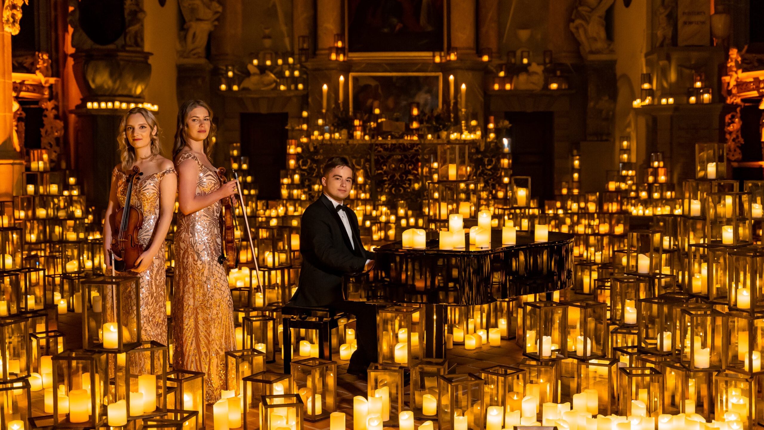 Violin-Spielerinnen und Pianist im Meer aus Kerzen bei den 1000 Lights Concerts 